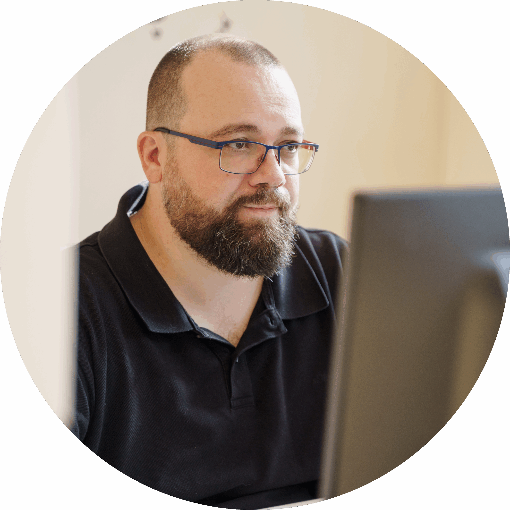 Mann mit Bart und Brille arbeitet konzentriert an einem Computerbildschirm